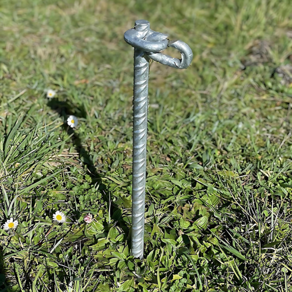 Piqueta (en uso) de hierro galvanizado en caliente, de 405 mm de largo y 20 mm de diámetro, con argolla soldada para sujeción. Ideal para anclar elementos en terrenos blandos. Se vende en paquetes de 10 unidades.